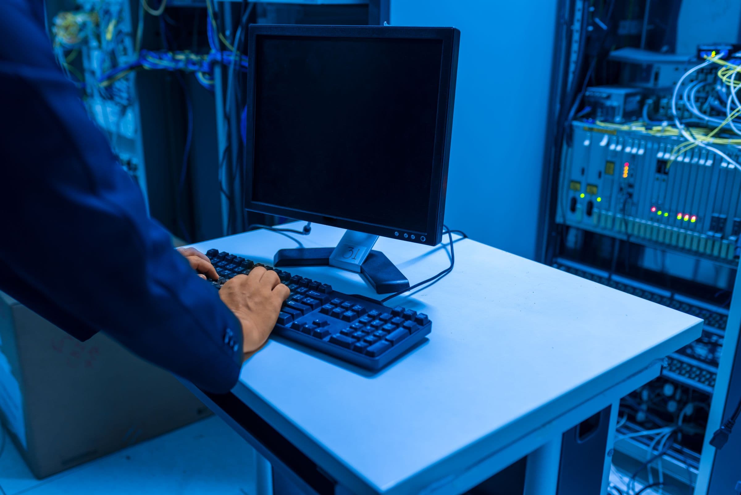 Ein IT-Fachmann arbeitet an einem Rechner im Serverraum
