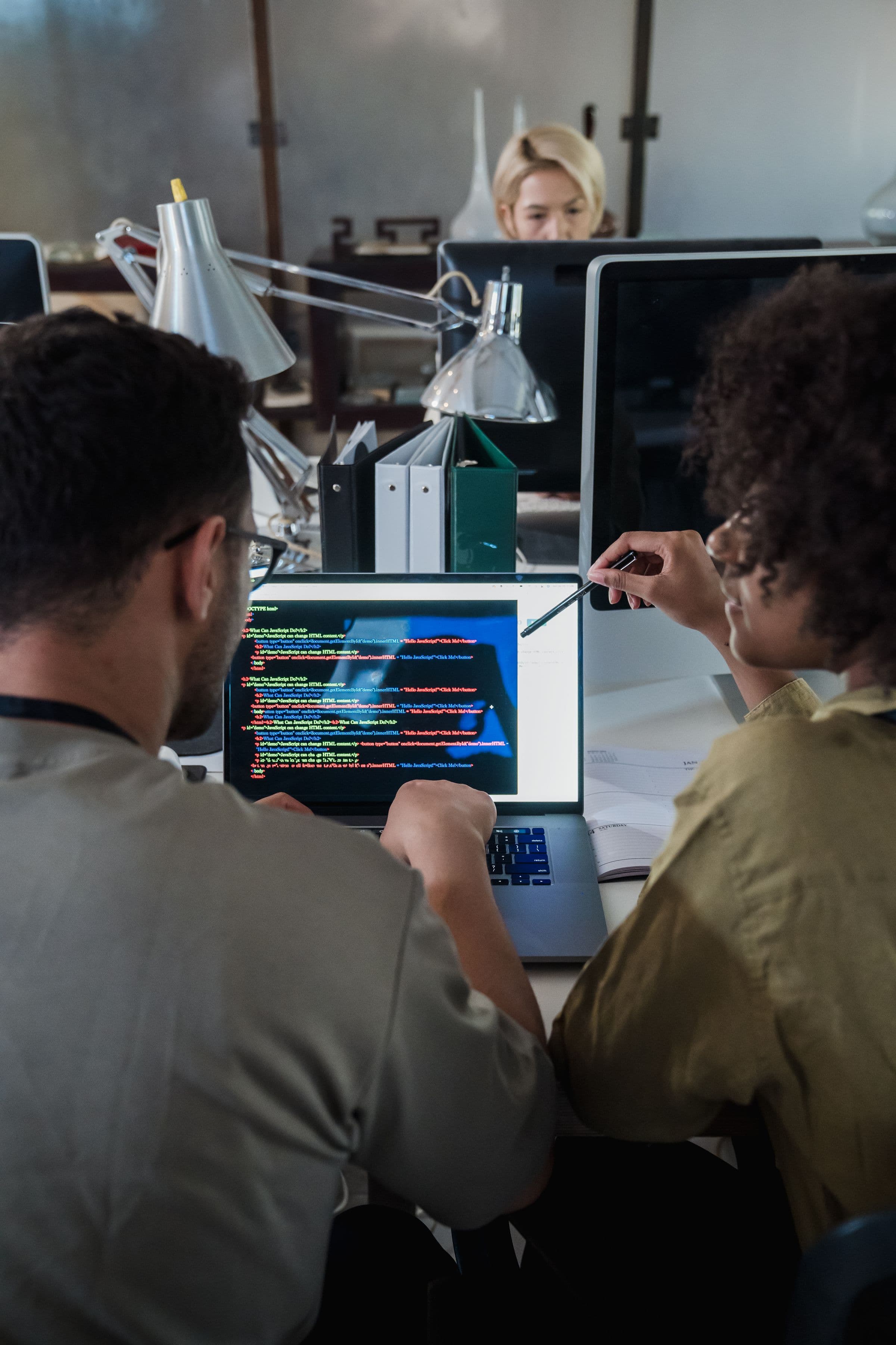 Zwei Entwickler arbeiten gemeinsam an Code auf einem Laptop